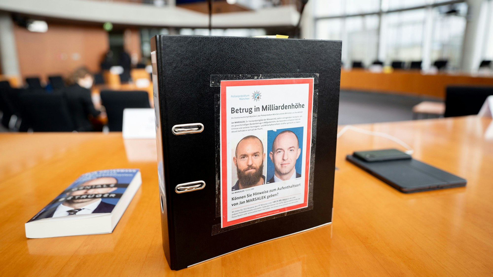 Der Aktenordner des ehemaligen Bundestagsabgeordneten de Masi (Die Linke) mit Fahndungsfotos des früheren Wirecard-Finanzvorstands Jan Marsalek ist im Sitzungssaal zum Bilanzskandal Wirecard im Paul-Löbe-Haus zu sehen.