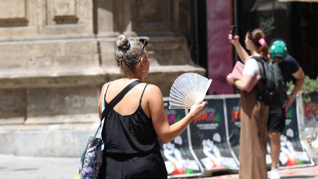 In Palermo benutzt eine Frau ihren Fächer während der Hitze.