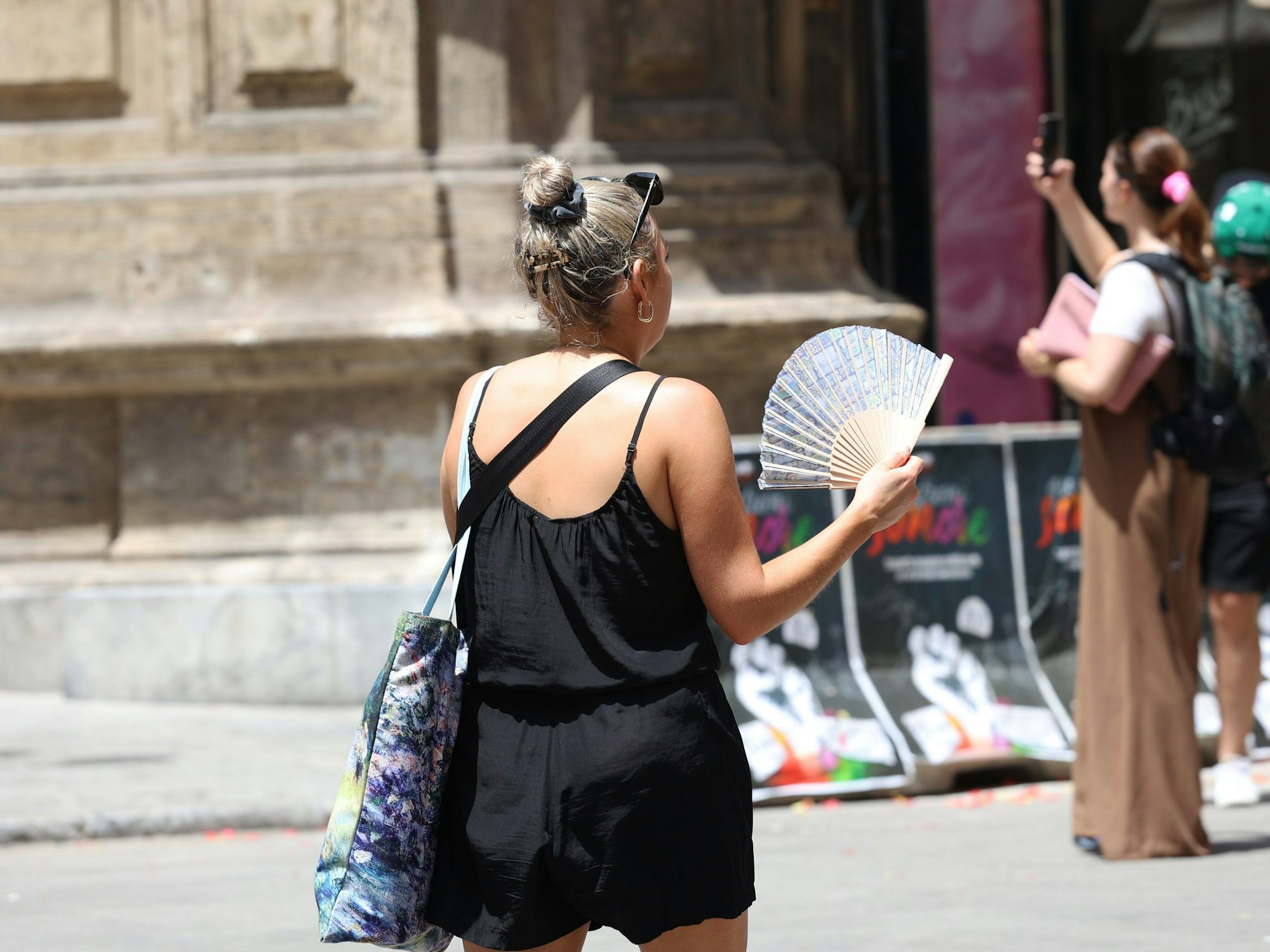 In Palermo benutzt eine Frau ihren Fächer während der Hitze.