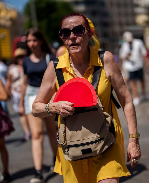 Hier wedelt sich eine Frau in Madrid Mitte Juli Luft zu.