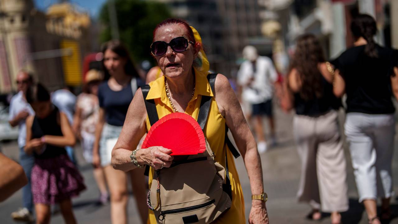 Hier wedelt sich eine Frau in Madrid Mitte Juli Luft zu.