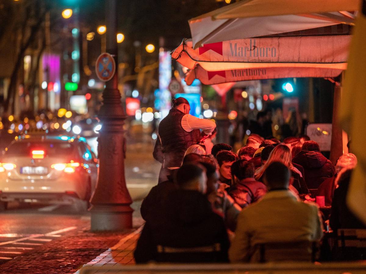 Menschen sitzen in einem Lokal auf den Kölner Ringen.