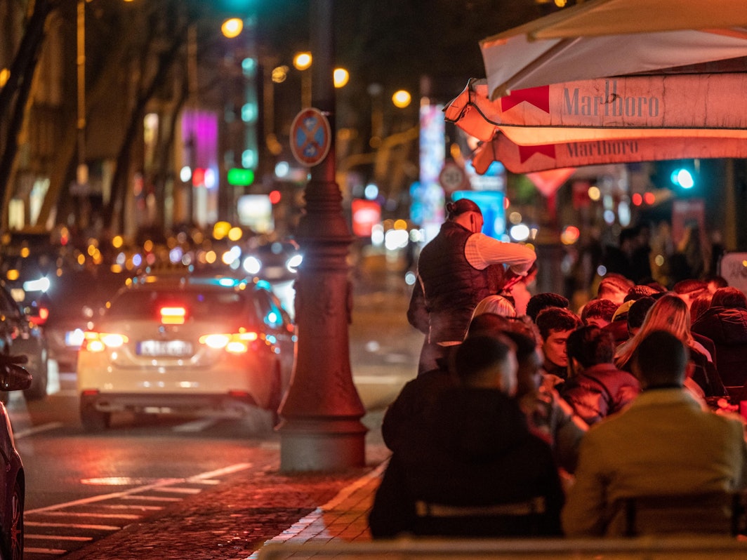Menschen sitzen in einem Lokal auf den Kölner Ringen.