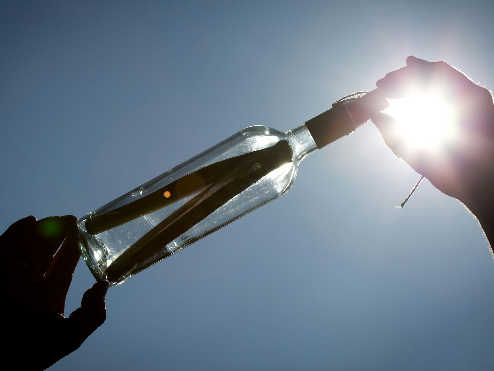 Ein Zettel steckt in einer Flaschenpost.