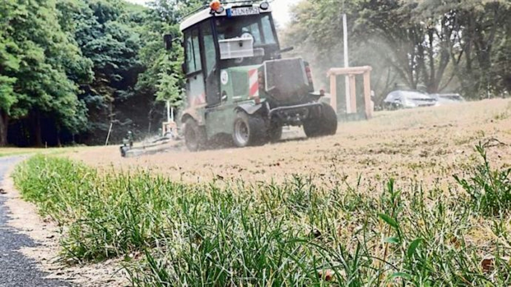 Ein Rasenmäher mäht das Grün an der Militärringstraße ab.