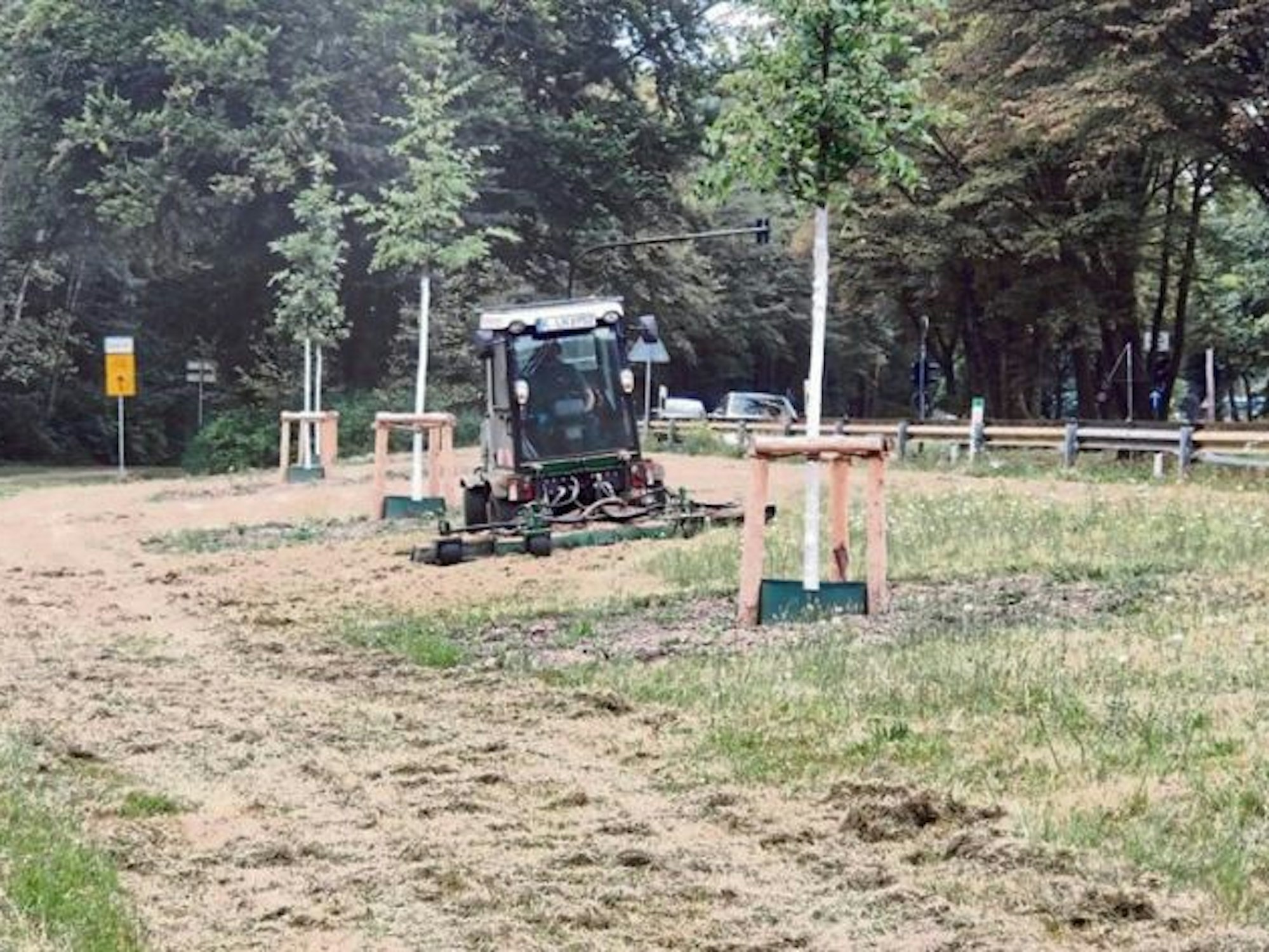 Ein Arbeiter mäht den Rasen an der Militärringstraße.