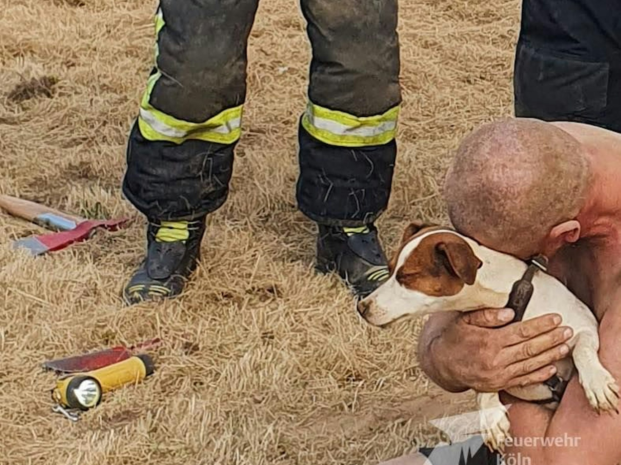 Ein Mann kniet auf dem Boden und drückt seinen Jack Russell an sich.