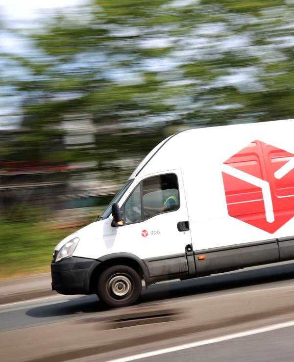 Ein DPD-Pakettransporter fährt über eine Straße.
