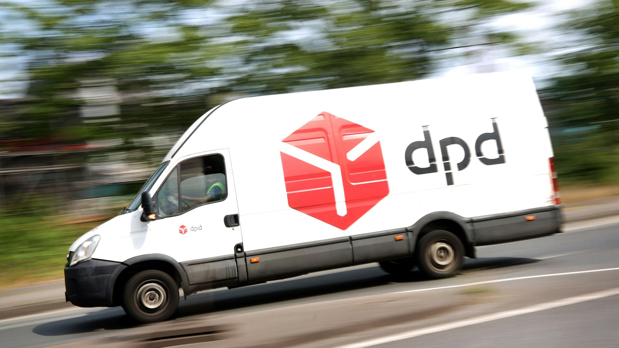 Ein DPD-Pakettransporter fährt über eine Straße.