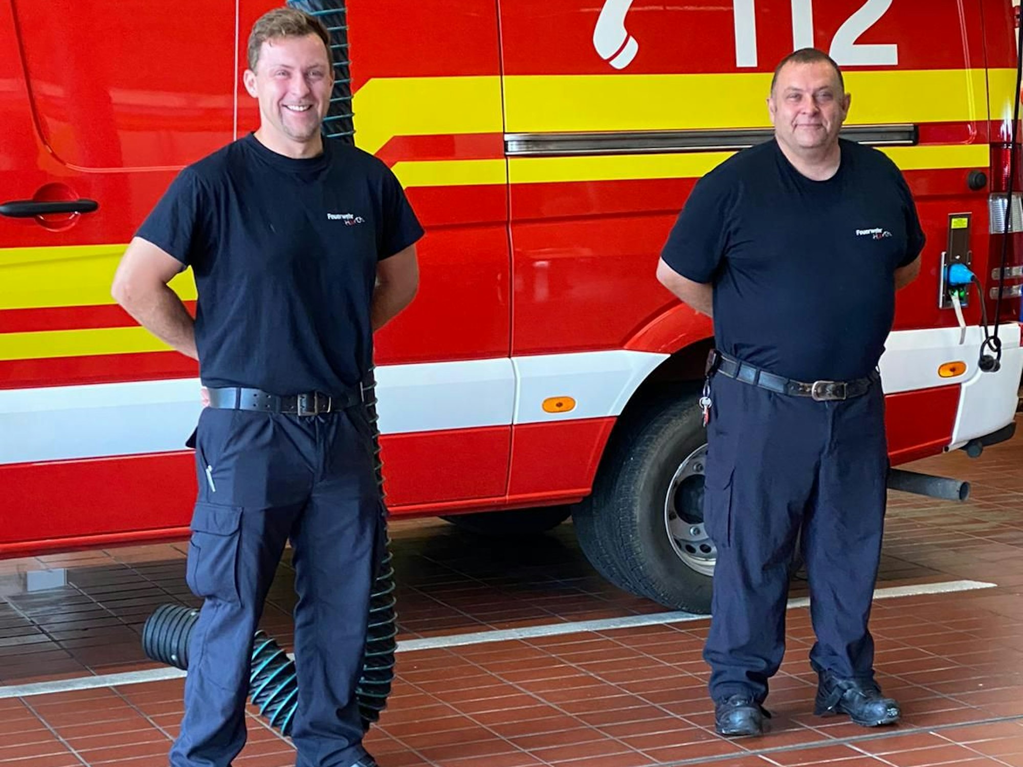 Martin Hoßdorf und sein Vater Hans-Jürgen stehen vor einem Feuerwehrfahrzeug.