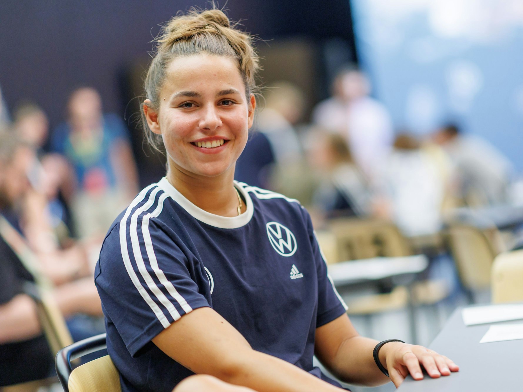 Lena Oberdorf sitzt auf einem Stuhl und schaut in die Kamera.