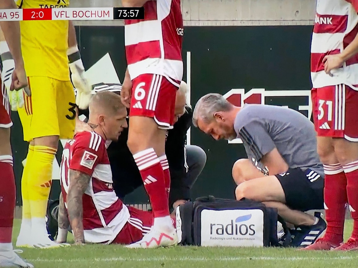 Jordy de Wijs von Fortuna Düsseldorf liegt nach seiner Verletzung im Test gegen den VfL Bochum am Boden und wird behandelt.