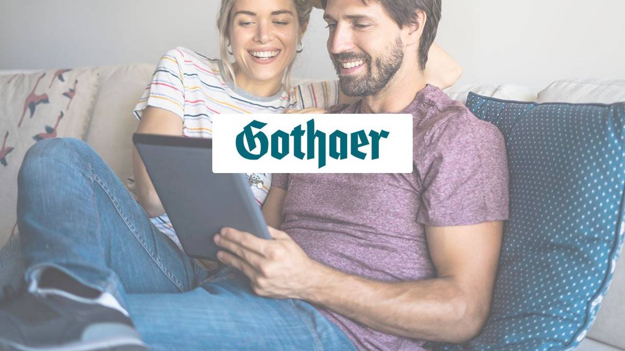 Mann und Frau sitzen auf Couch und schauen lächelnd auf ein Tablet. Logo der Gothaer Versicherung im Vordergrund.