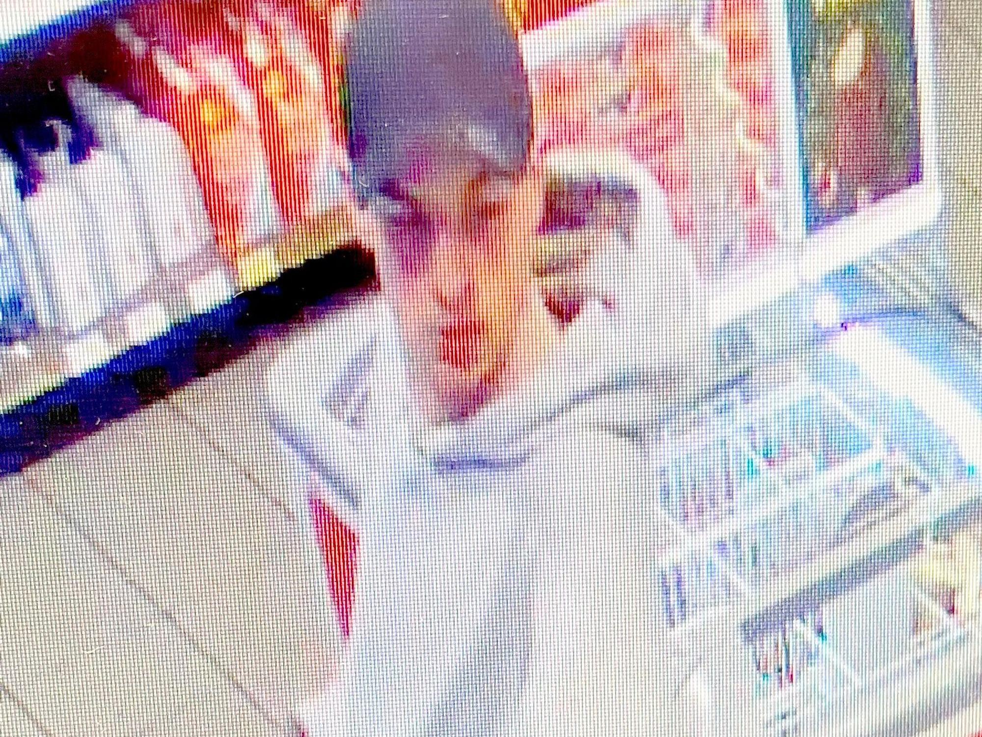 Fahndungsfoto eines Mannes mit Kappe und weißem Pullover, der eine Tankstelle überfällt.