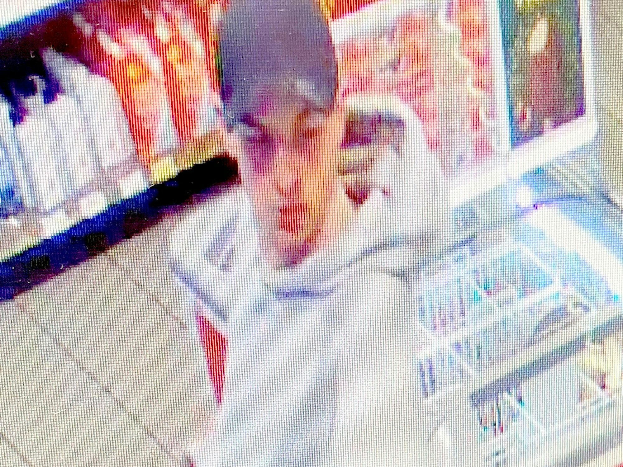 Fahndungsfoto eines Mannes mit Kappe und weißem Pullover, der eine Tankstelle überfällt.