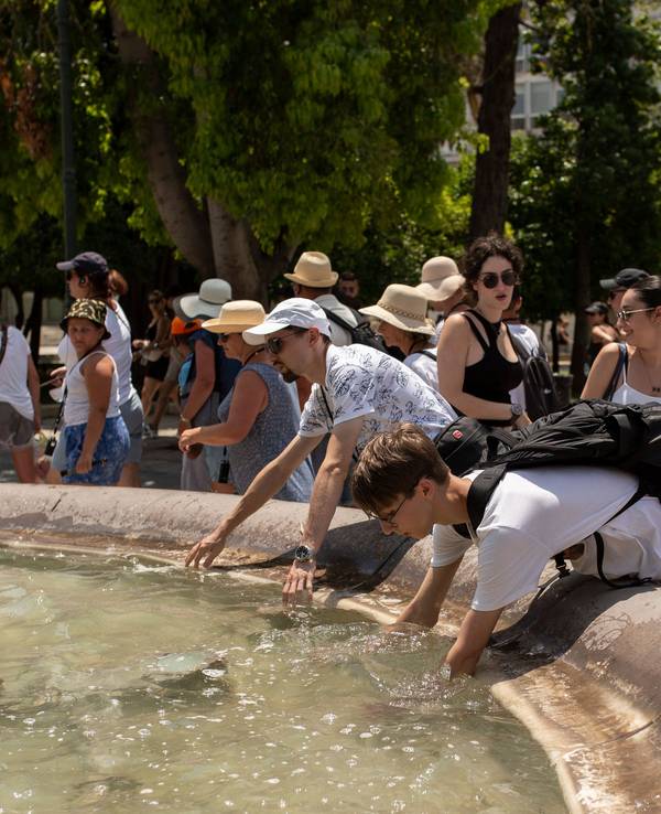 Menschen an einem Brunnen in Athen.