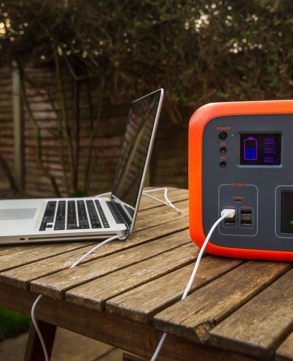 Auf dem Foto sieht man einen Laptop, der an eine Powerstation angeschlossen ist.