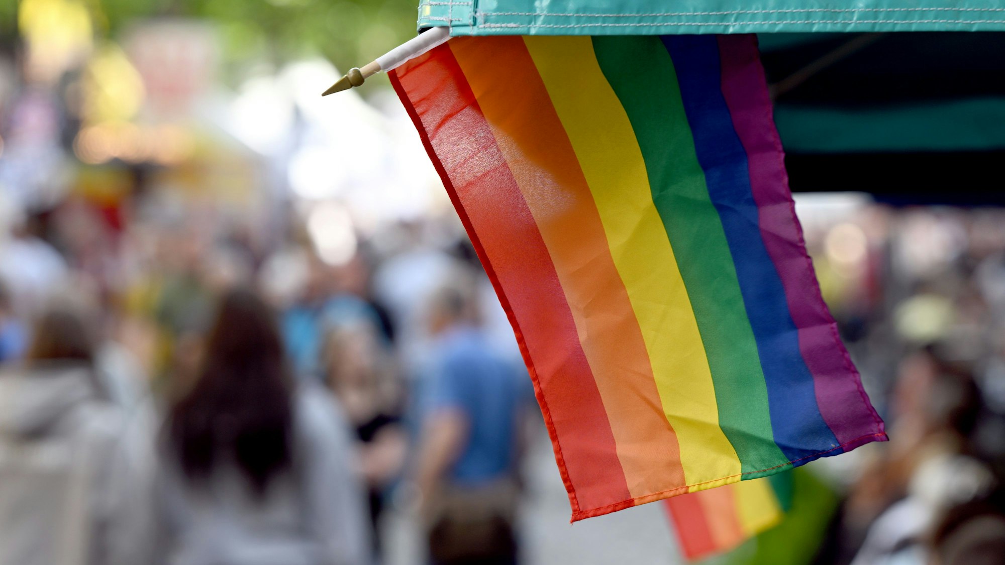Regenbogenflaggen sind an einem Marktstand angebracht.