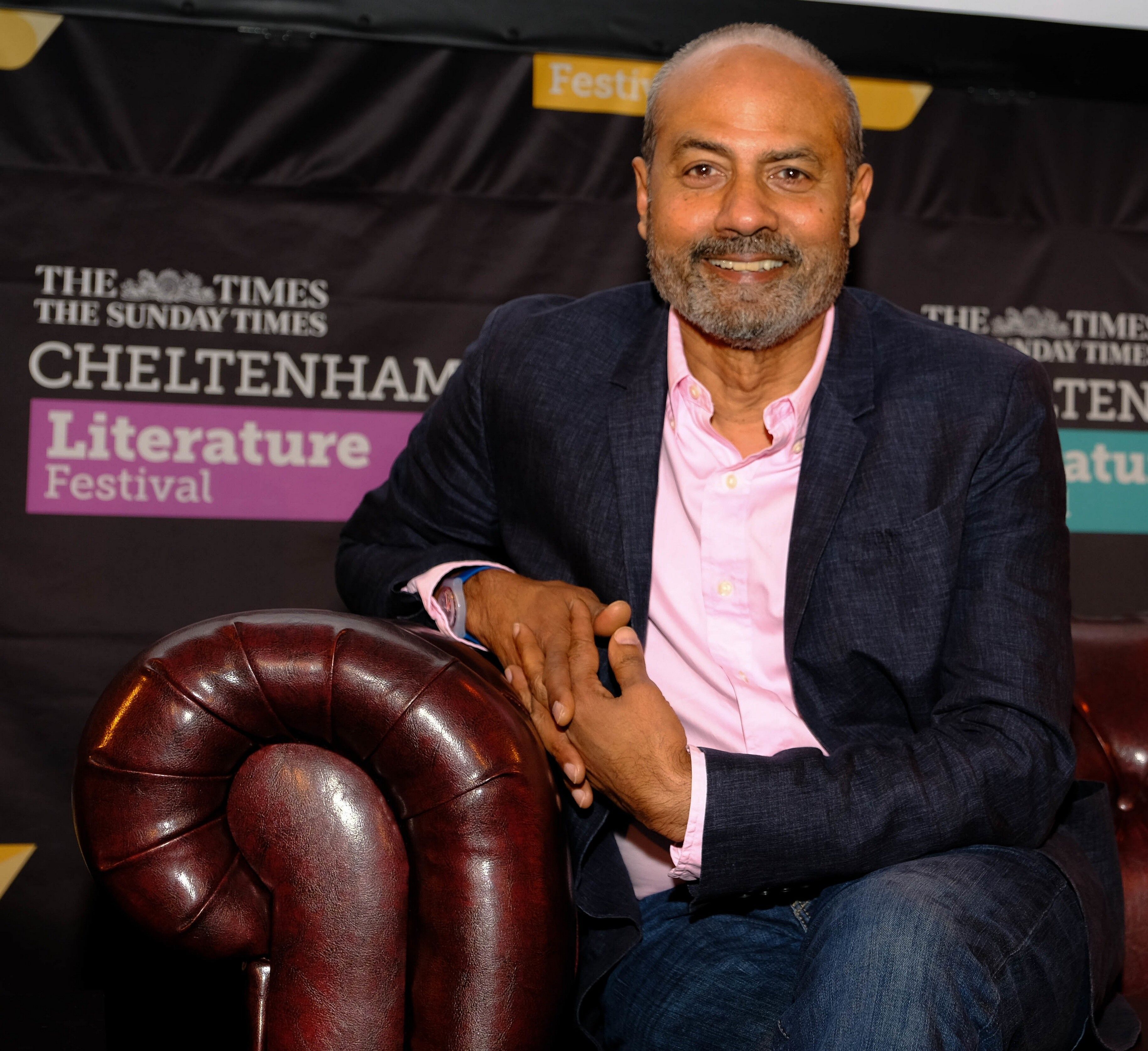 BBC-Moderator und Journalist George Alagiah sitzt auf einer Couch.