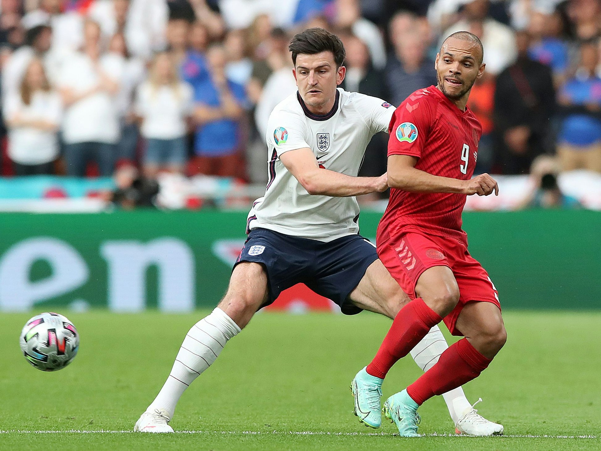 Englands Harry Maguire (l) und Dänemarks Martin Braithwaite kämpfen um den Ball.