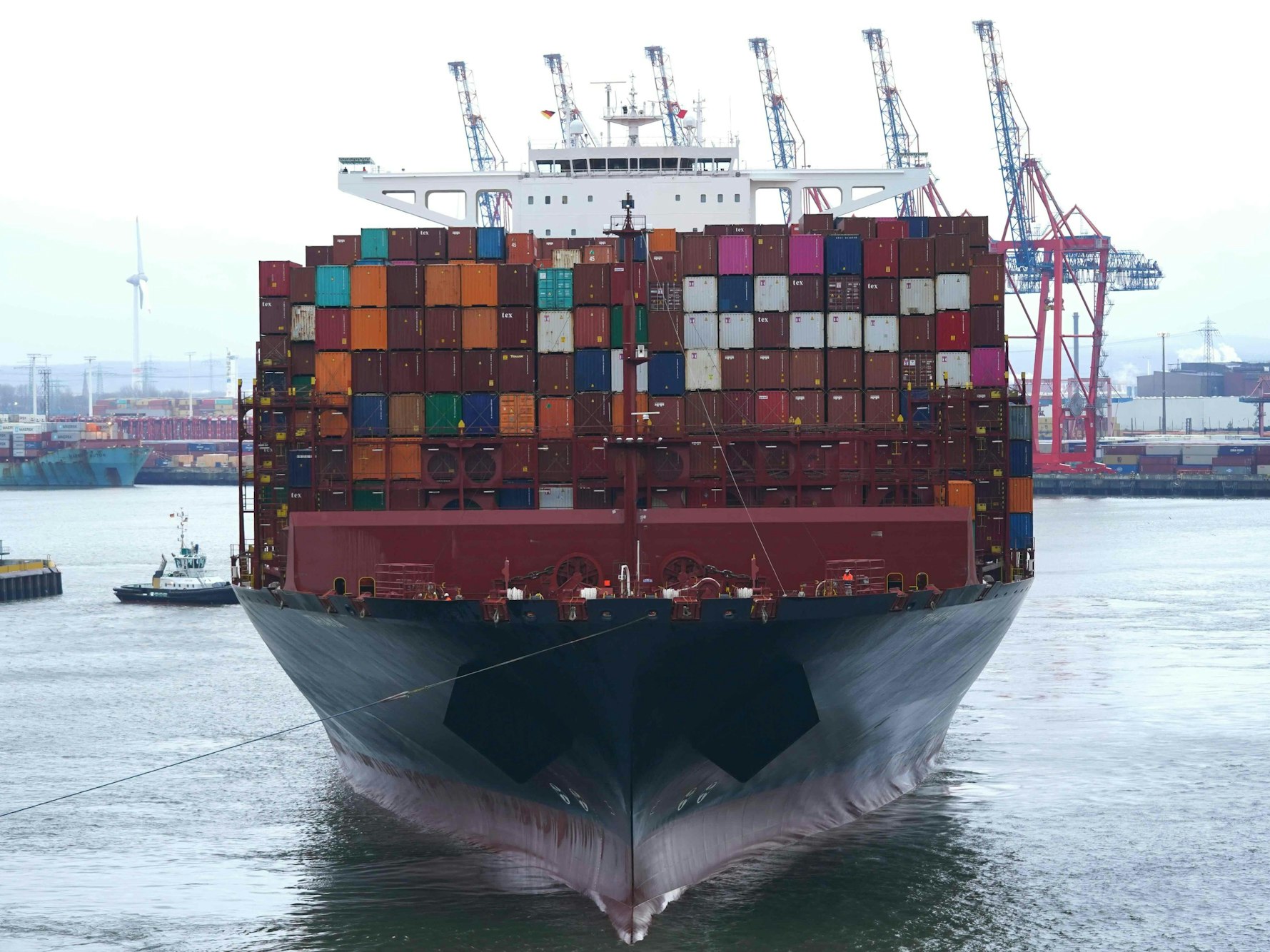 Das riesige Containerschiff „Tihama“ von der Reederei Hapag-Lloyd wird auf der Elbe an einen Containerterminal geschleppt, hier im März 2023 in Hamburg.