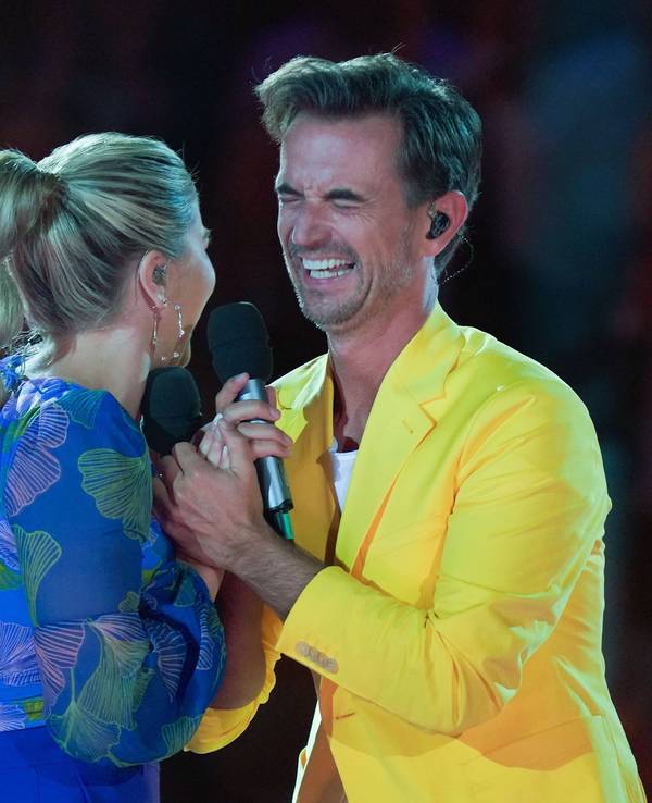 Florian Silbereisen und Beatrice Egli halten sich an den Händen.