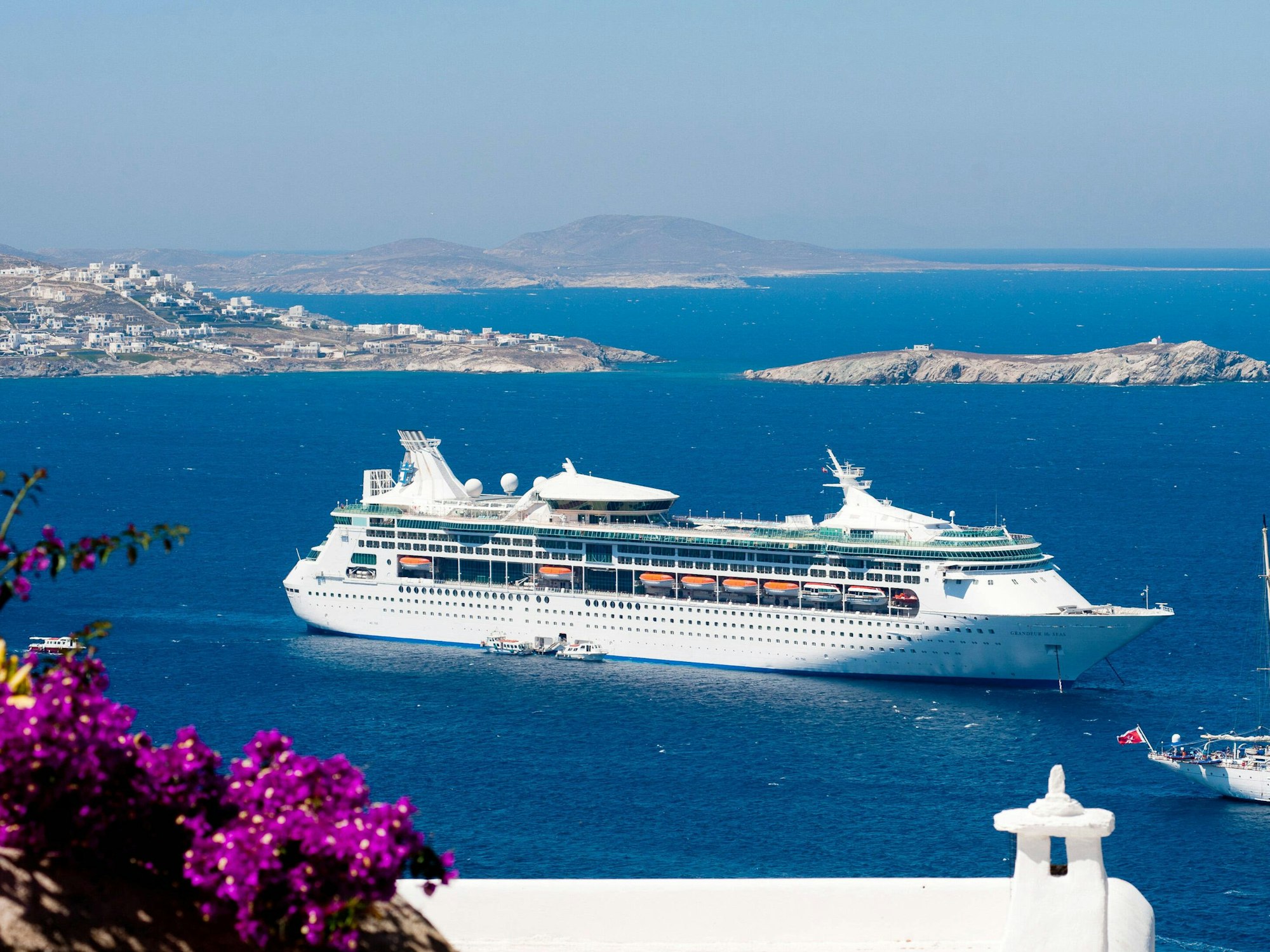 Ein riesiges Kreuzfahrtschiff ankert vor Mykonos.