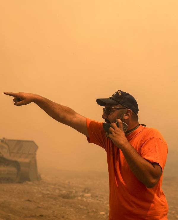 Ein freiwilliger Helfer gibt während eines Waldbrandes Anweisungen.