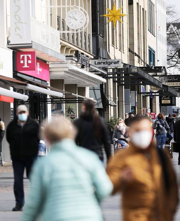 Menschen gehen mit Masken durch die Innenstadt von Siegburg.