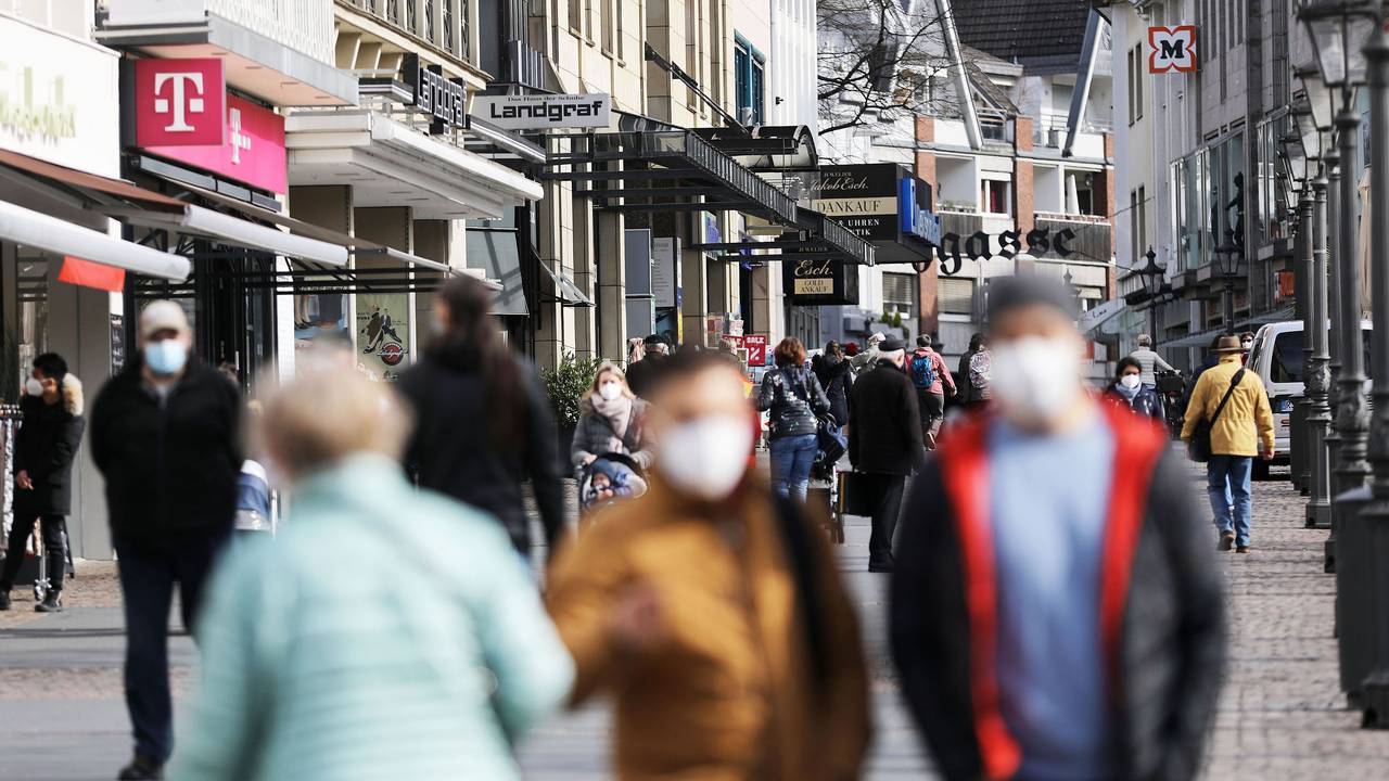 Menschen gehen mit Masken durch die Innenstadt von Siegburg.