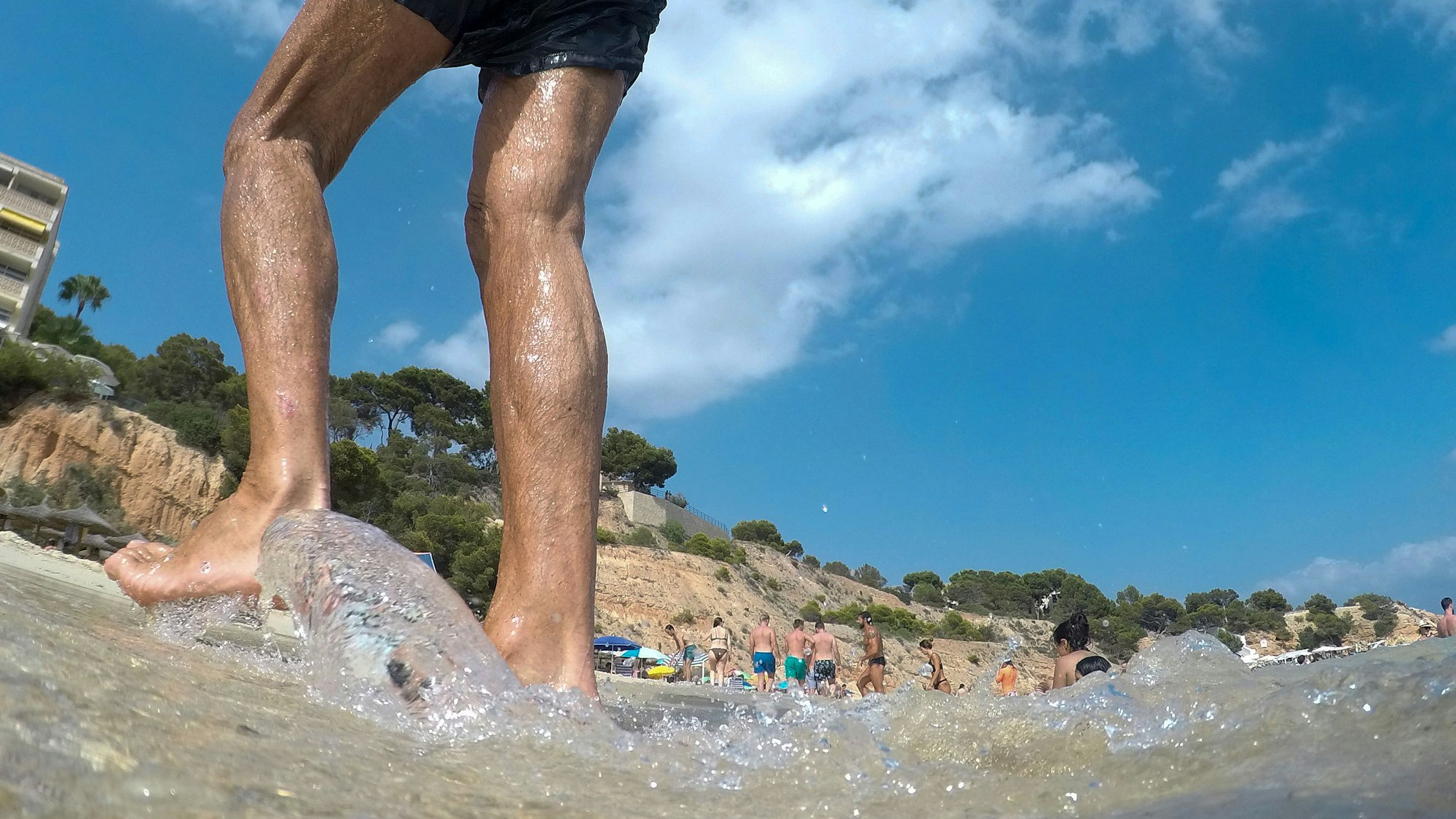 Ein Mann spaziert am Strand auf Mallorca entlang.
