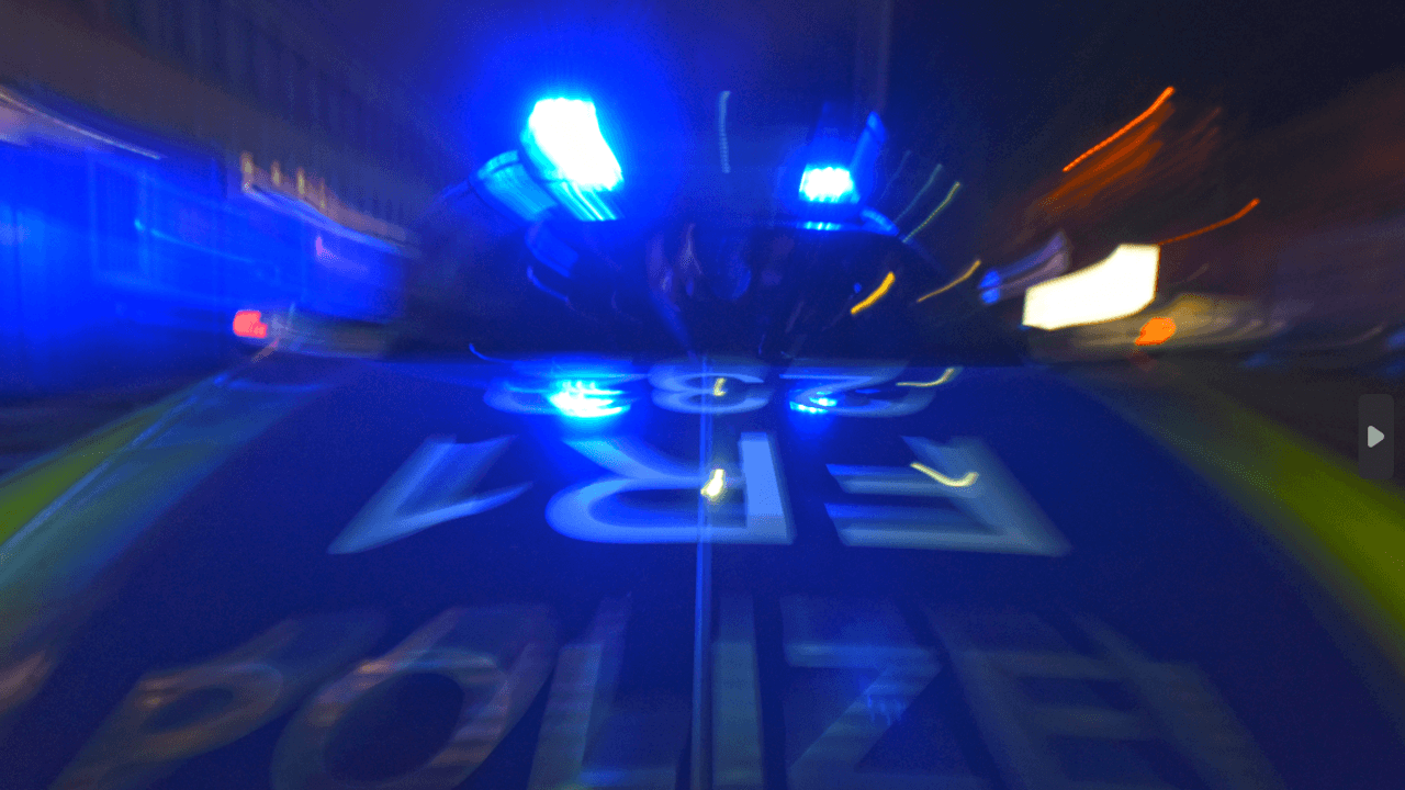 Ein Polizeifahrzeug steht mit Blaulicht auf der Straße.