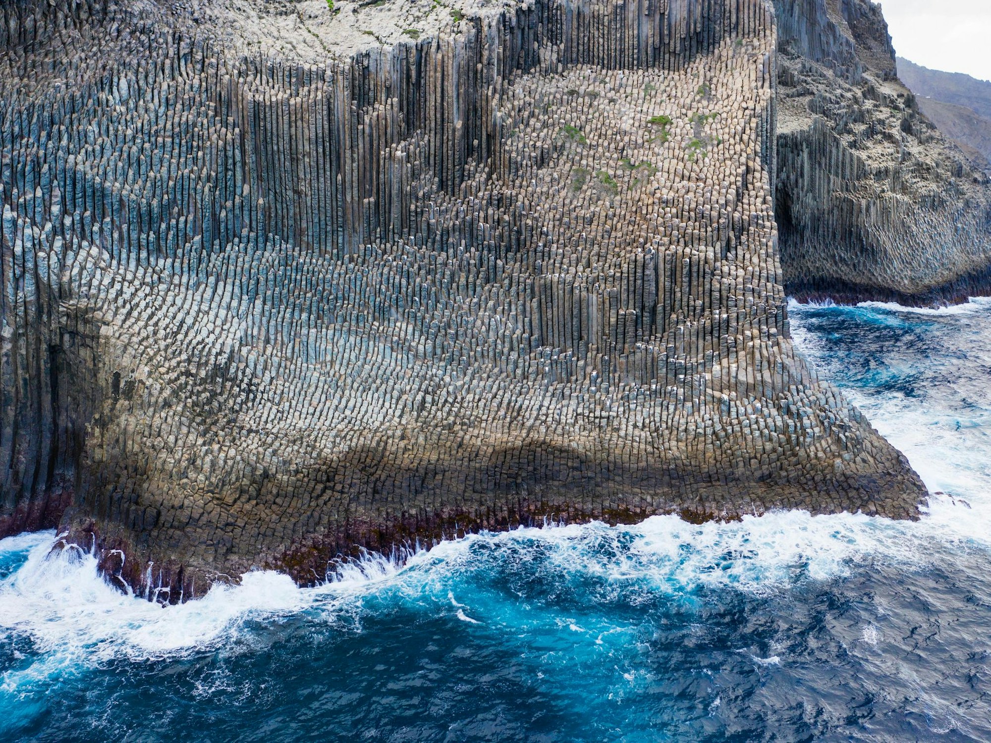 Blaues Meer prallt an Basalatsäulen ab.