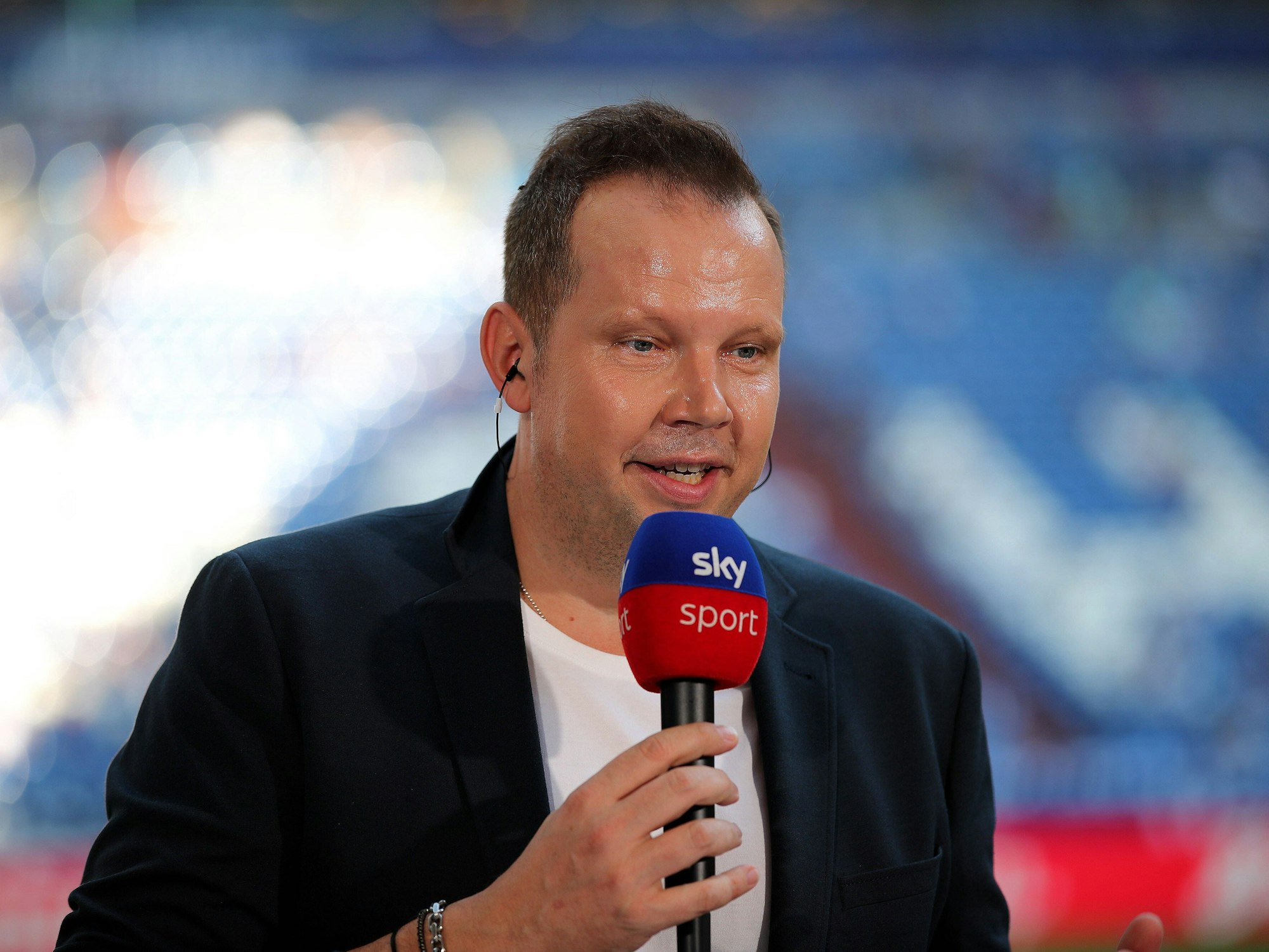 Wolff-Christoph Fuss hält bei einer Sky-Übertragung ein Mikrofon in der Hand.