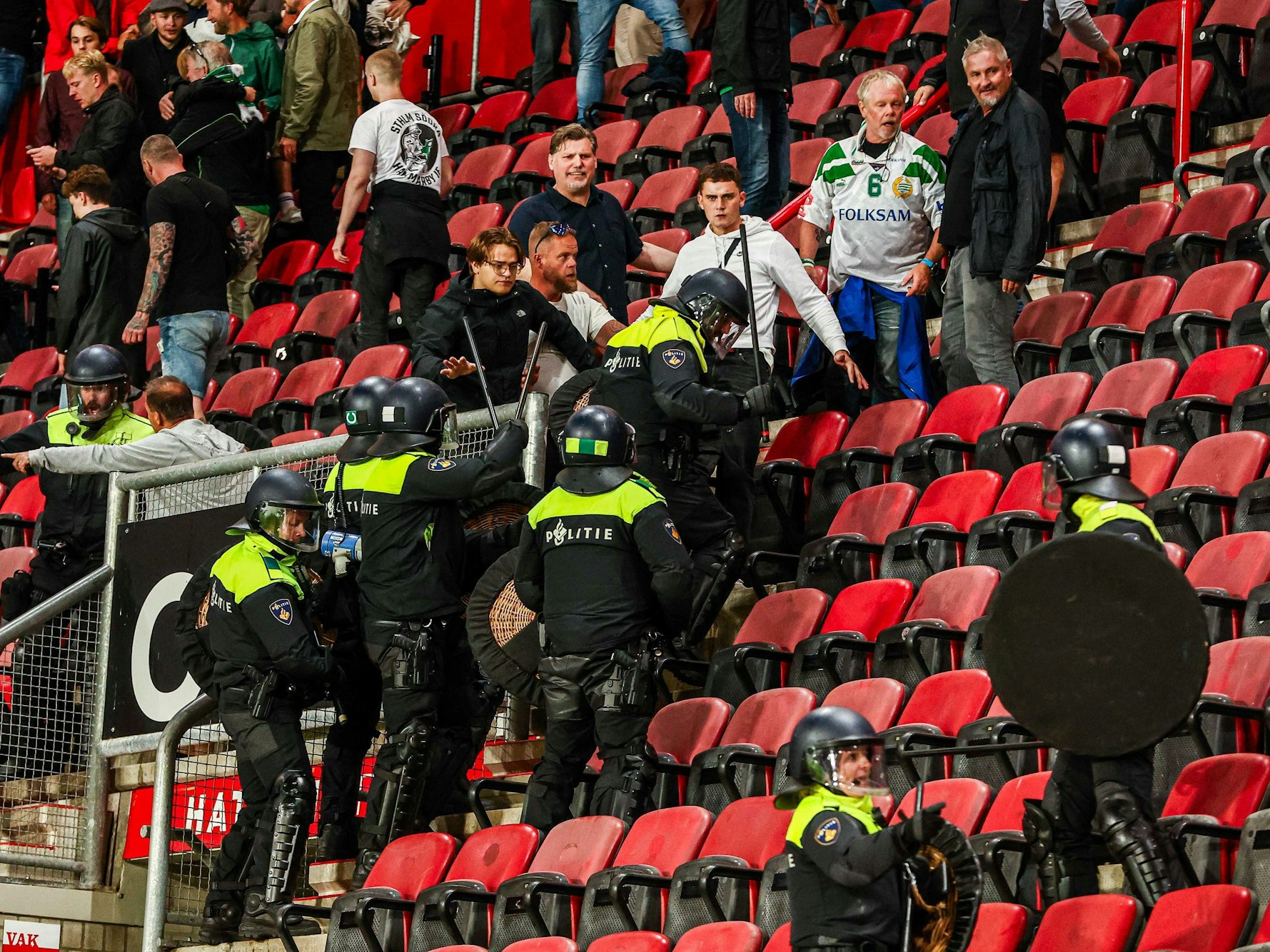 Polizisten agieren mit Fans während Unruhen auf der Tribüne.