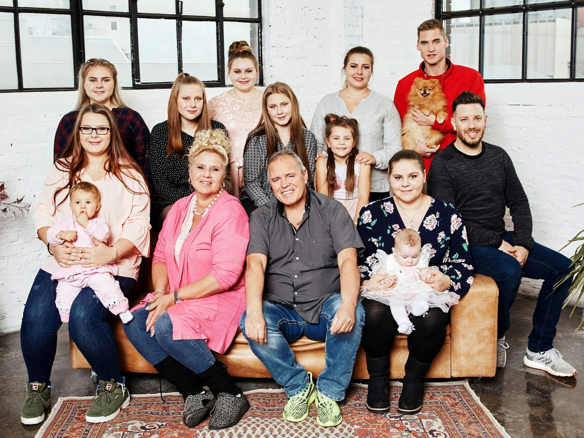 Familie Wollny sitzt für ein Foto zusammen.