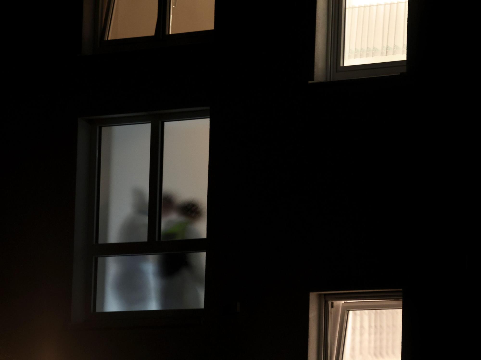 Beamte der Spurensicherung arbeiten im Treppenhaus eines Mehrfamilienhauses, in dem drei Menschen erschossen wurden.
