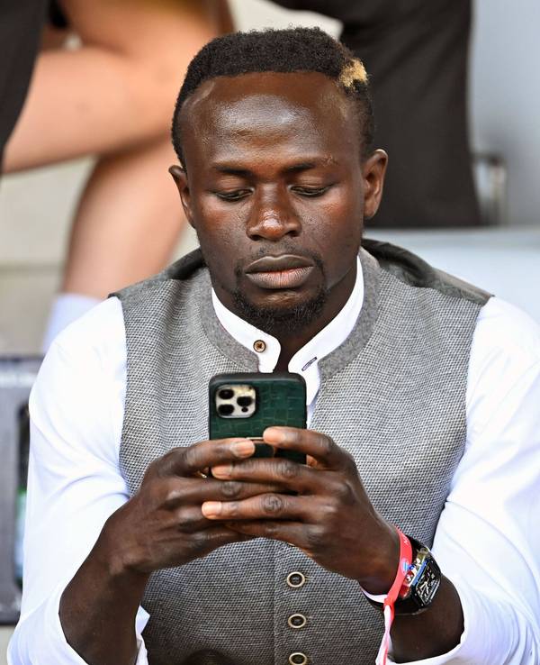 Sadio Mané schaut auf sein Smartphone.