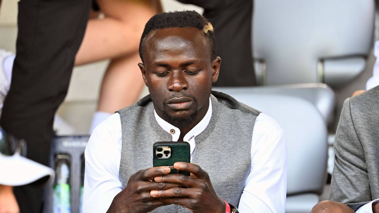 Sadio Mané schaut auf sein Smartphone.