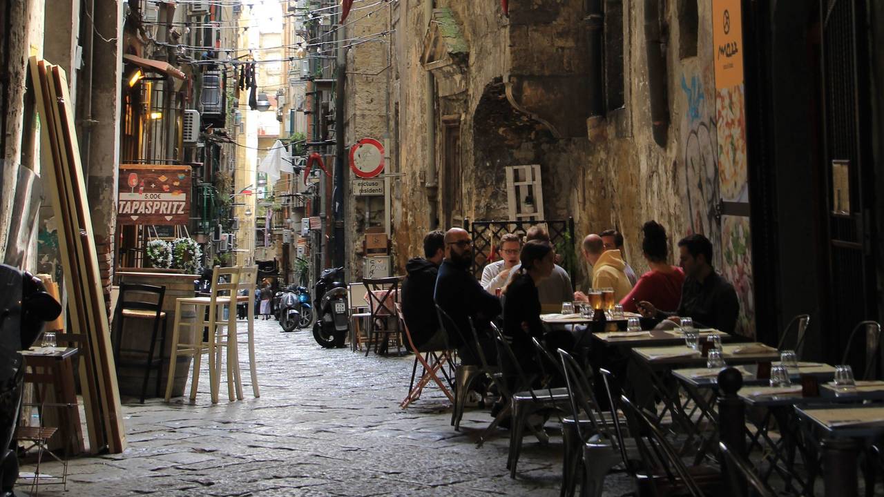 Menschen sitzen in einem Restaurant in der Innenstadt von Neapel. Um die Ursprünglichkeit ihres historischen Stadtkerns zu bewahren, verbietet die süditalienische Stadt Neapel für drei Jahre die Eröffnung neuer Restaurants und Bars.
