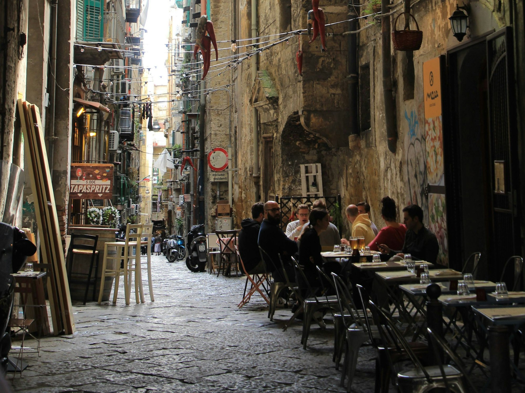 Menschen sitzen in einem Restaurant in der Innenstadt von Neapel. Um die Ursprünglichkeit ihres historischen Stadtkerns zu bewahren, verbietet die süditalienische Stadt Neapel für drei Jahre die Eröffnung neuer Restaurants und Bars.