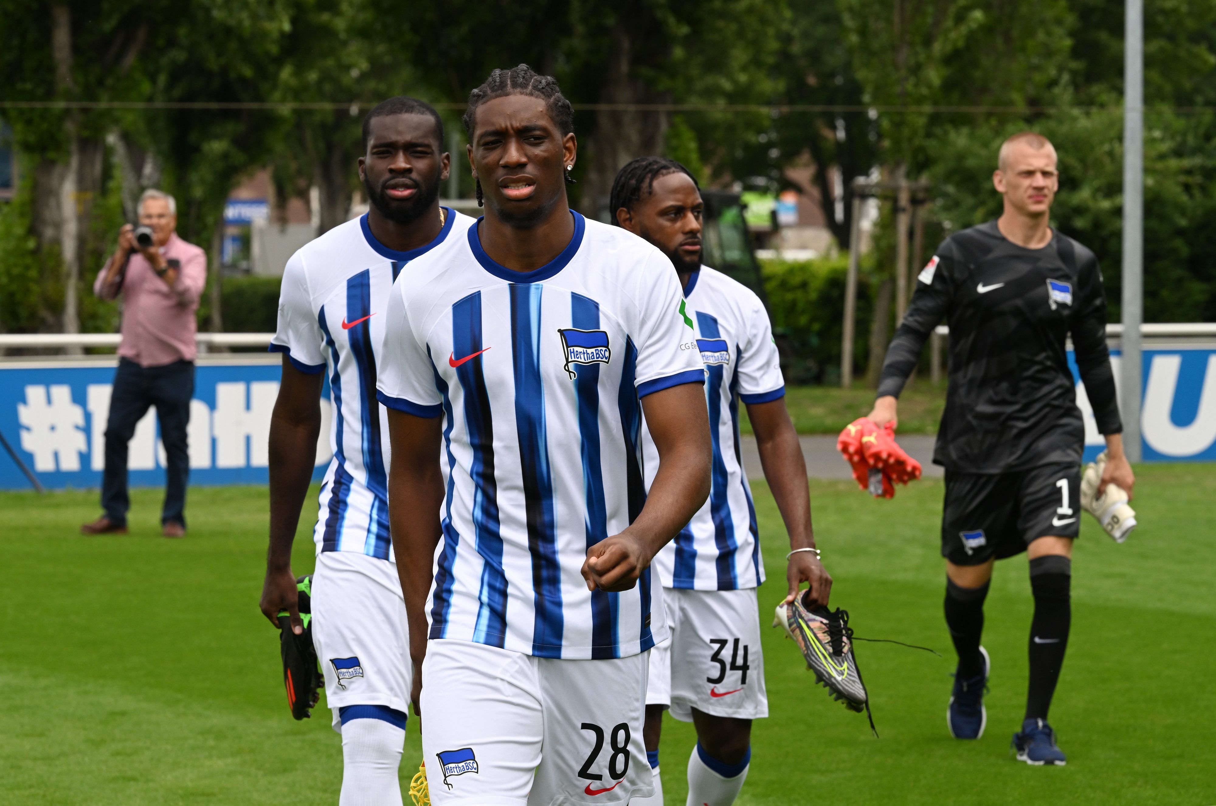 Herthas Wilfried Kanga (l-r), Kelian Nsona und Deyovaisio Zeefuik gehen über den Rasen.