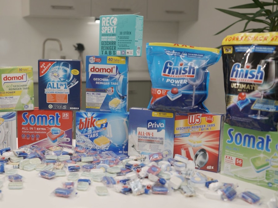 Verschiedene Packungen von Spülmaschinentabs auf einem Tisch aufgestellt.