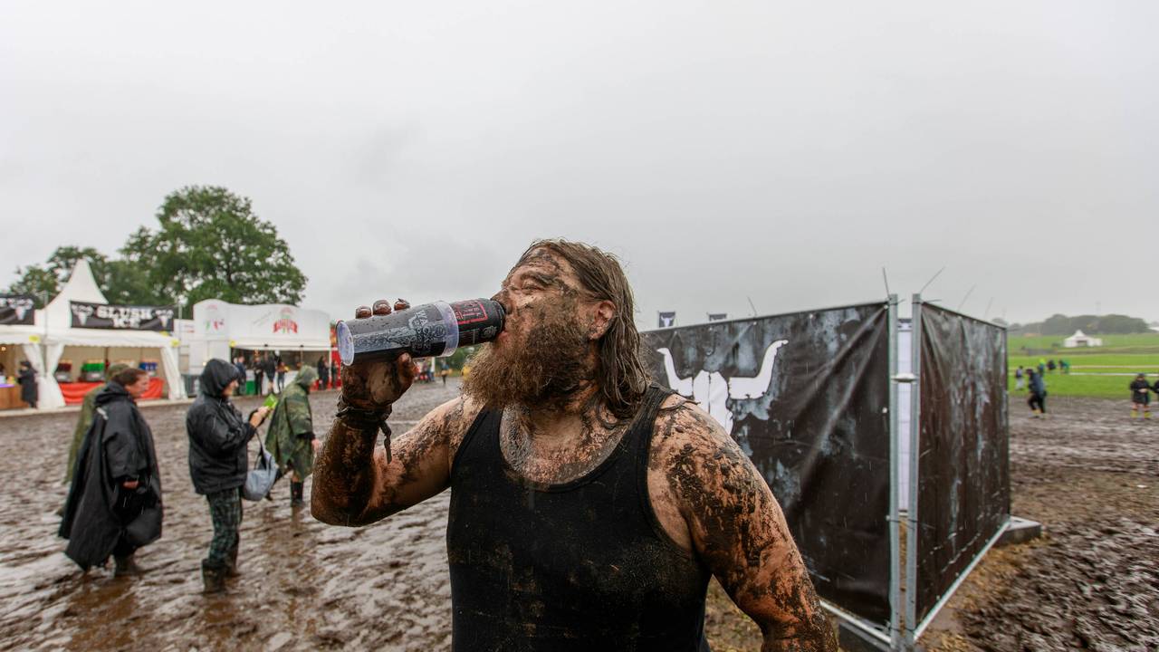 Ein Mann trotzt auf dem Gelände des Wacken Open Air dem Regen und Schlamm.