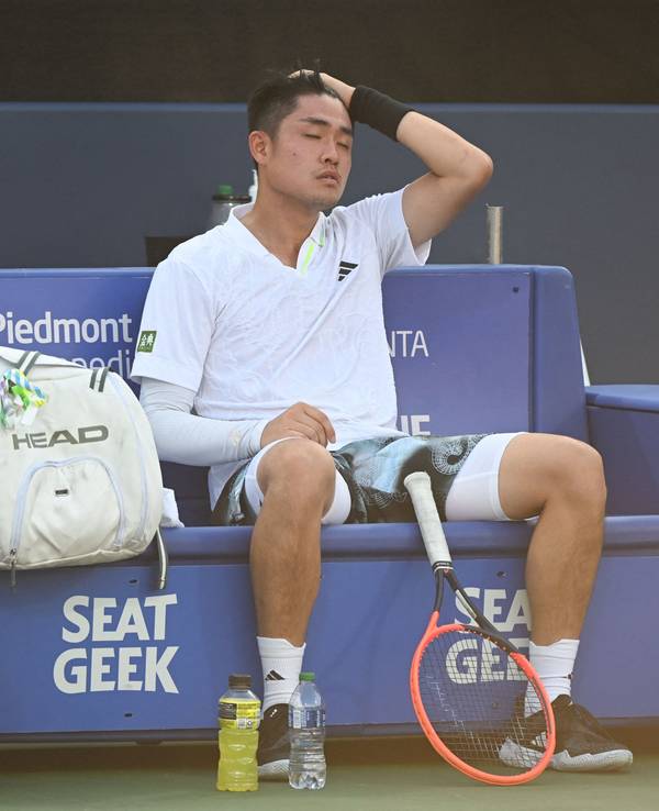 Wu Yibing sitzt beim ATP-Turnier in Atlanta erschöpft auf der Bank.