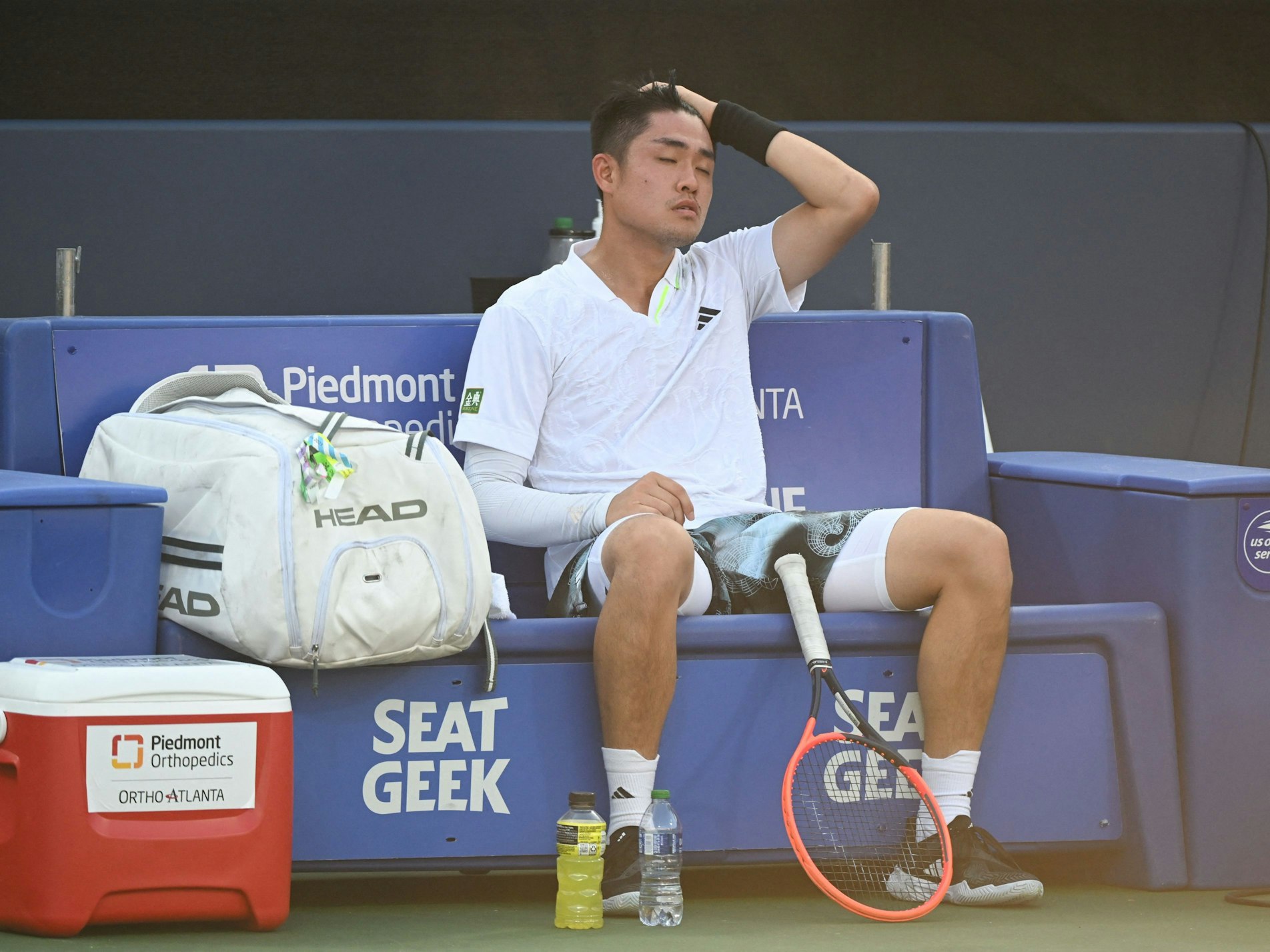 Wu Yibing sitzt beim ATP-Turnier in Atlanta erschöpft auf der Bank.