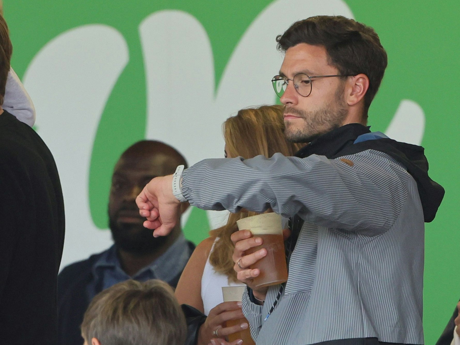 Jonas Hector schaut auf der Zuschauertribüne auf die Uhr.