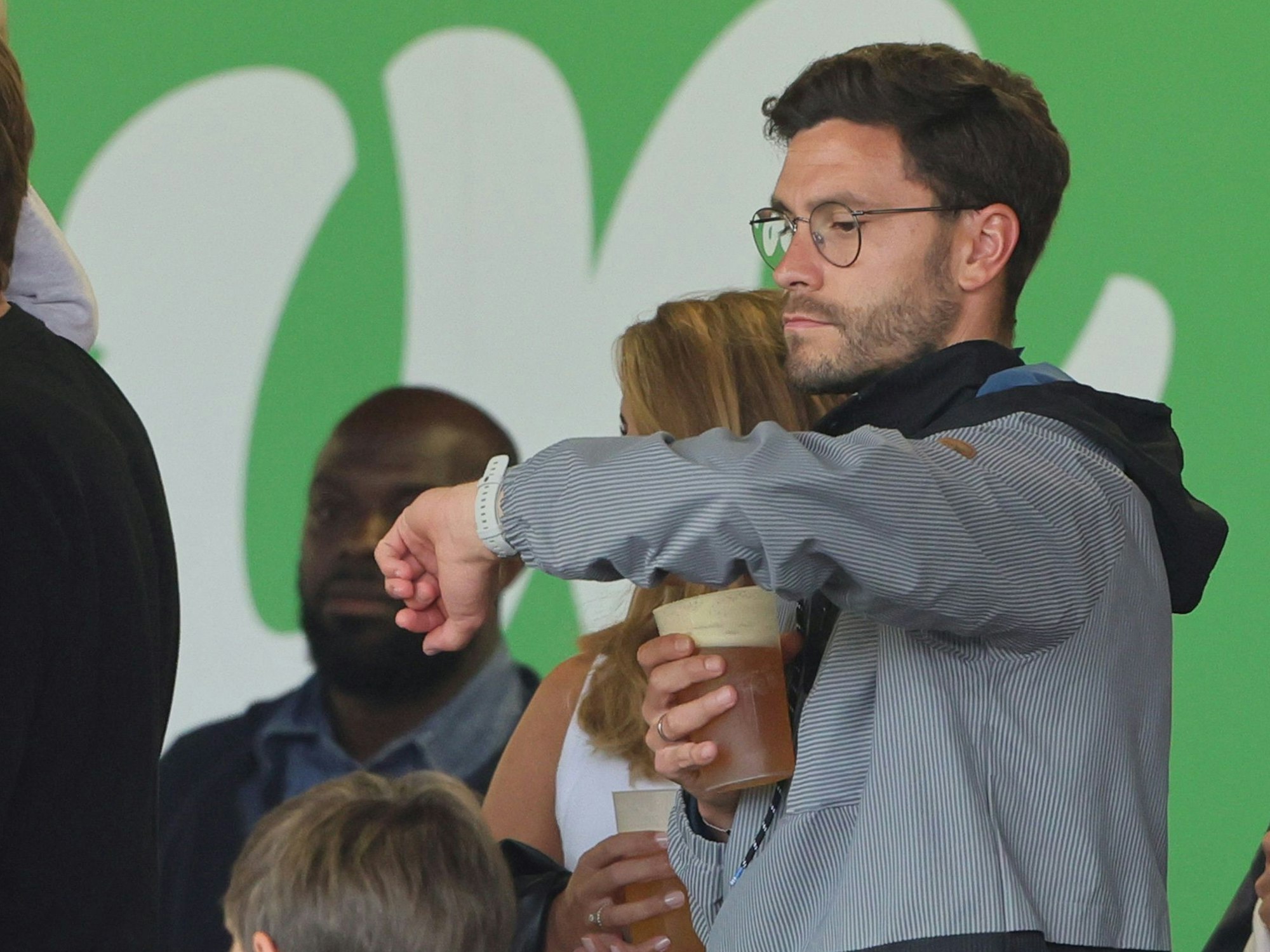 Jonas Hector schaut auf der Zuschauertribüne auf die Uhr.