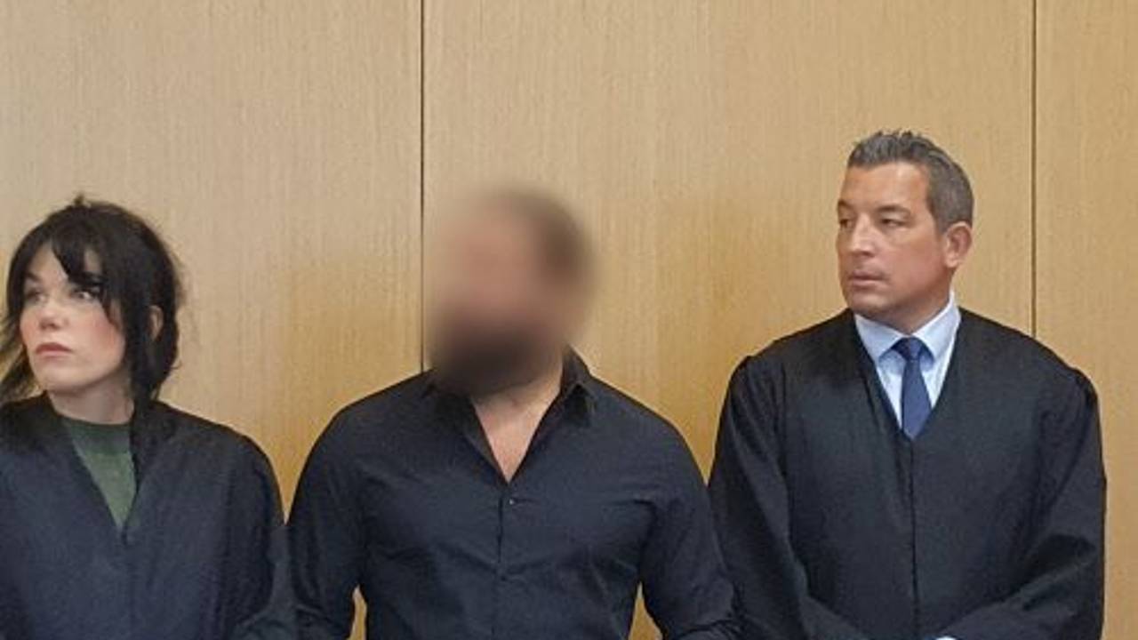 Der Angeklagte (M) steht am 1. August 2023 neben seiner Verteidigerin Franziska Ernst (l) und seinem Verteidiger Wolf Bonn im Gerichtssaal.