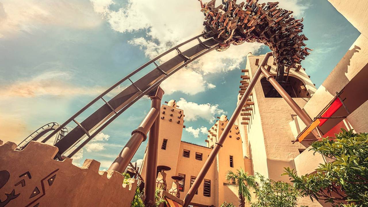 Eine Achterbahn fährt in einem Freizeitpark.